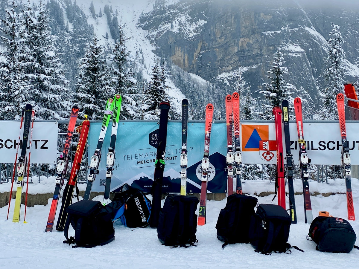 a group of skis and backpacks sitting in the snow